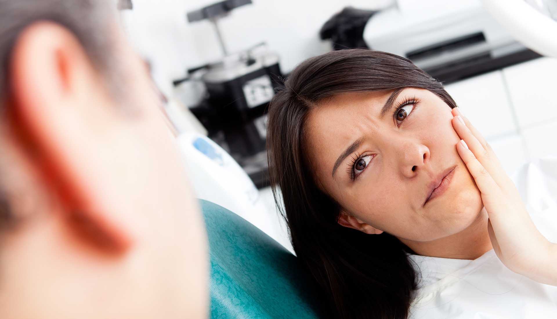 Woman at the dentist complaining about a tooth pain.