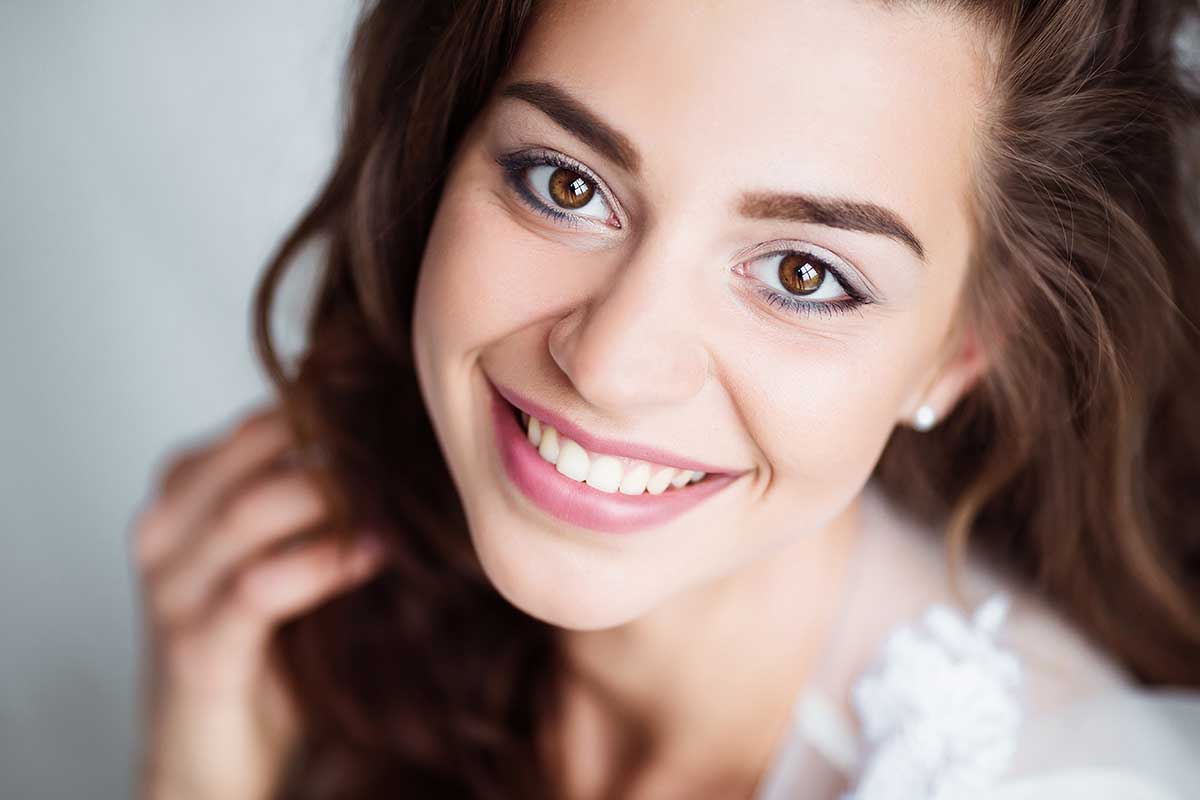 Portrait of smiling woman with perfect smile and white teeth looking at camera.